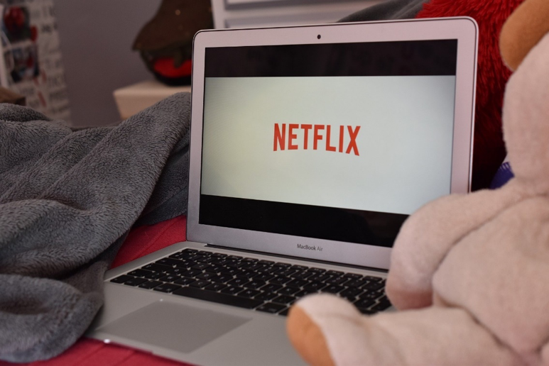Notebook mit Netflix auf dem Display liegt auf einem Bett